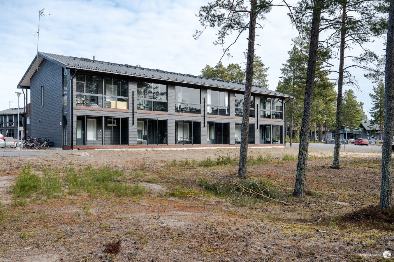 Moderni rakennus, jossa on tasakatto, suuret ikkunat sekä lasi- ja metallimateriaalien yhdistelmä.