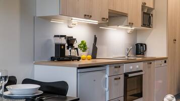 A modern kitchen with a coffee machine, sink, and cabinets.