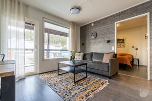 A modern living room with a sofa, coffee table, and a patterned rug. - Polar Charm F Holiday in Lapland (Ylläs)