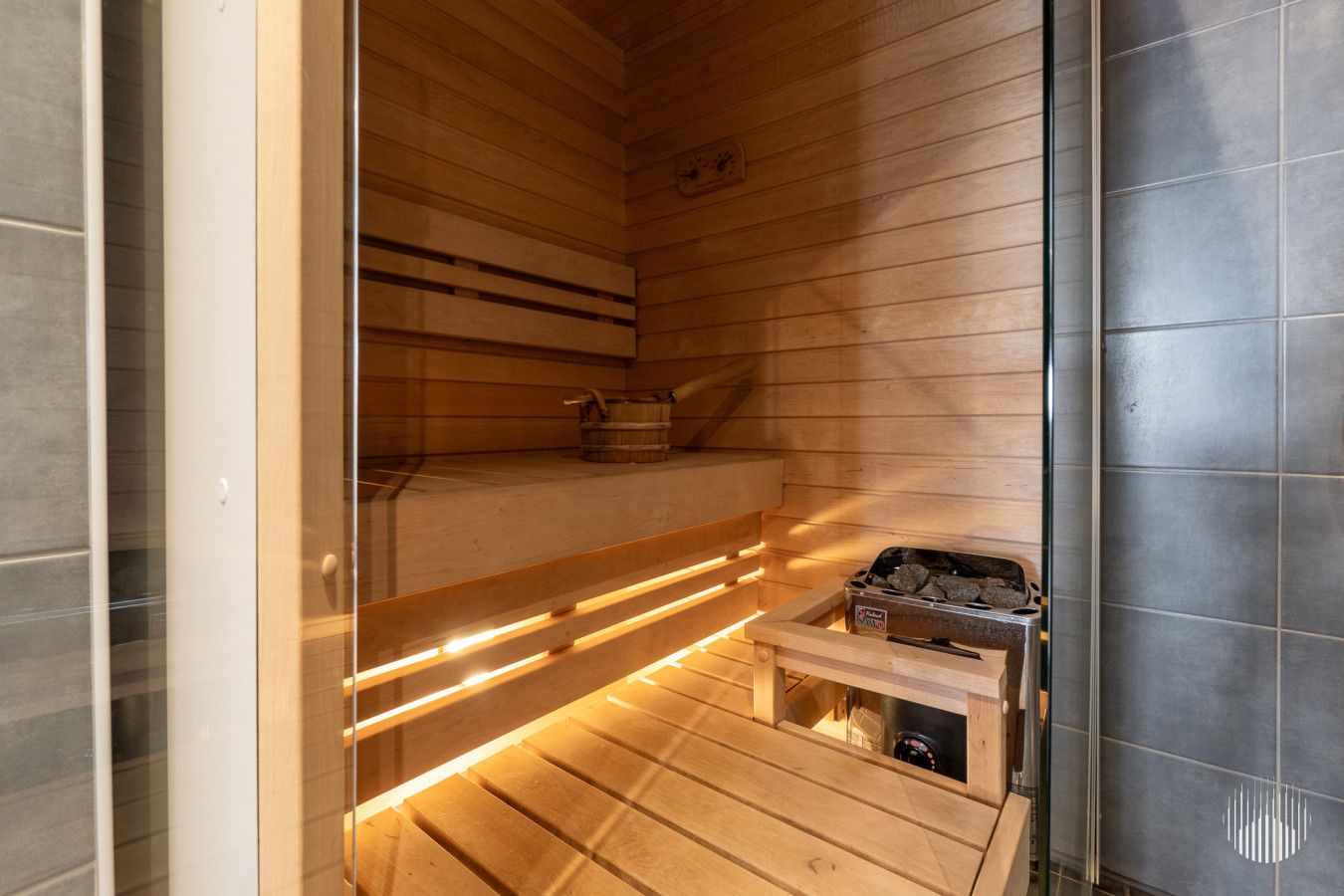 A sauna with wooden benches and a visible heater.
