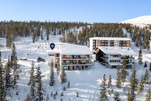 A modern ski resort with multi-story buildings, snow-covered surroundings, and a clear sky. - Polar Charm F Holiday in Lapland (Ylläs)