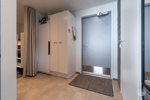 A hallway with a wardrobe, a door, and a mat. - Polar Charm G Holiday in Lapland (Yll äs)