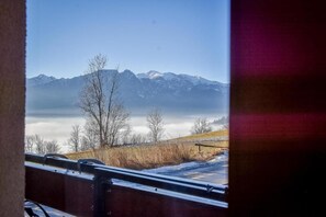 A mountainous landscape with a clear sky, a wooden fence, and a snow-covered ground. - Willa Piękne Widoki (Poronin)