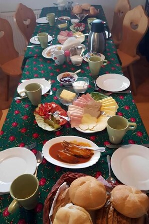 A dining table set with various dishes, including bread, cheese, and a bowl of soup. - Willa Piękne Widoki (Poronin)