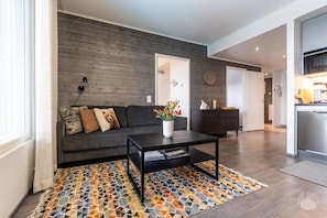 A modern living room with a sofa, coffee table, and patterned rug. - Polar Charm H Holiday in Lapland (Ylläs)