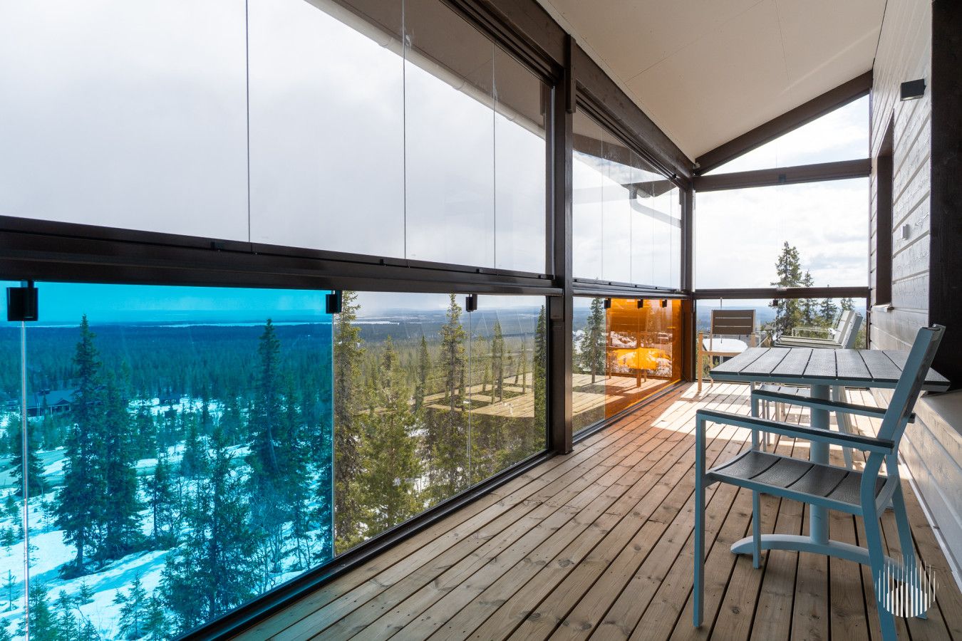 A modern interior with large windows offering a view of a forested landscape.