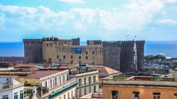 Un château historique doté de nombreuses tours, situé dans une ville côtière, avec des bâtiments en premier plan.