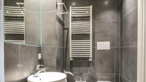 A modern bathroom with a large mirror, a sink, a toilet, and a bidet. - IL GRATTACIELO B&B (Napoli)