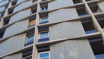 Un immeuble de grande hauteur, doté de nombreux étages, de grandes fenêtres et de balcons.