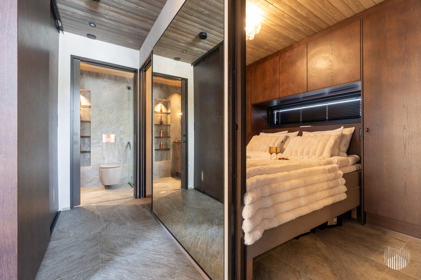 Un dormitorio moderno con una cama grande, un cabecero de madera y un separador de vidrio.