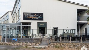 Um edifício com uma placa que indica 'BeachRose Cafe & Bar'.