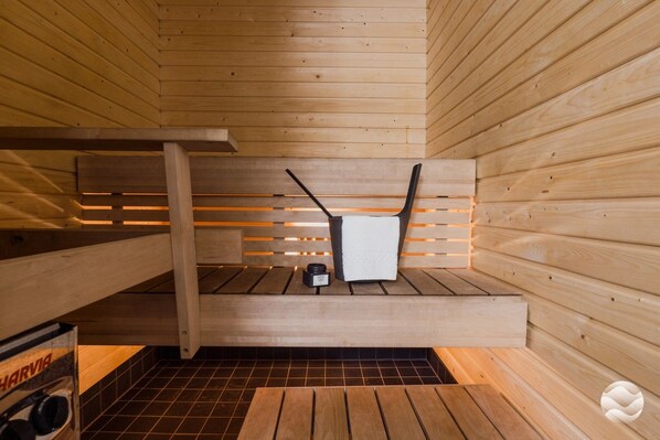 A sauna with wooden benches and a small heater.