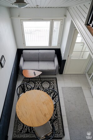 A room with a gray sofa, a round wooden table, and a patterned rug. - Moonlight 211 by Holiday in Lapland (Levi)
