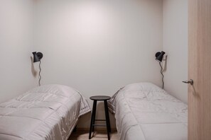 A room with two beds, a small stool, and two wall-mounted lamps. - Äkäsentie 1 A 309 by Holiday in Lapland (Äkäslompolo)