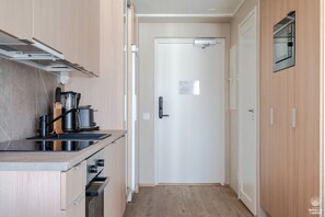 Une cuisine moderne équipée d’un four encastré, d’un four à micro-ondes et d’une machine à café.