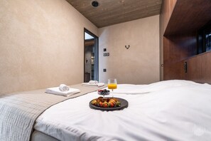 A hotel room with a bed, a tray of breakfast, a glass of orange juice, and towels. - North Suite Sky by Holiday in Lapland (Levi)