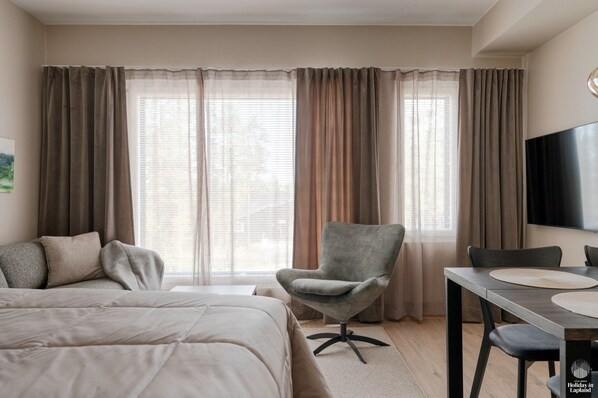 Ein Hotelzimmer mit Bett, Schreibtisch, Stuhl und Fernseher.