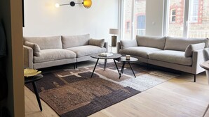 Una sala de estar moderna con dos sofás, una mesa de centro y una lámpara.