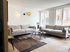 Un salon moderne avec deux canapés, une table basse et une lampe.