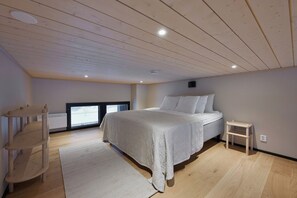 A bedroom with a bed, a small table, a window, and a radiator. - Metsonlinna 204 by Holiday in Lapland (Levi)