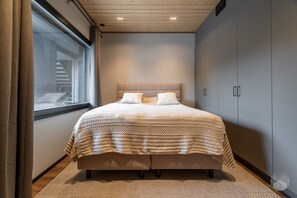 Ein Schlafzimmer mit einem großen Bett, einem Fenster und einem Kleiderschrank.