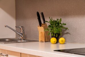 A kitchen counter with a sink, a knife block, and two lemons.
