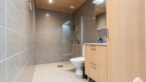 Et stilfuldt badeværelse med bruser, toilet og vaskebord.