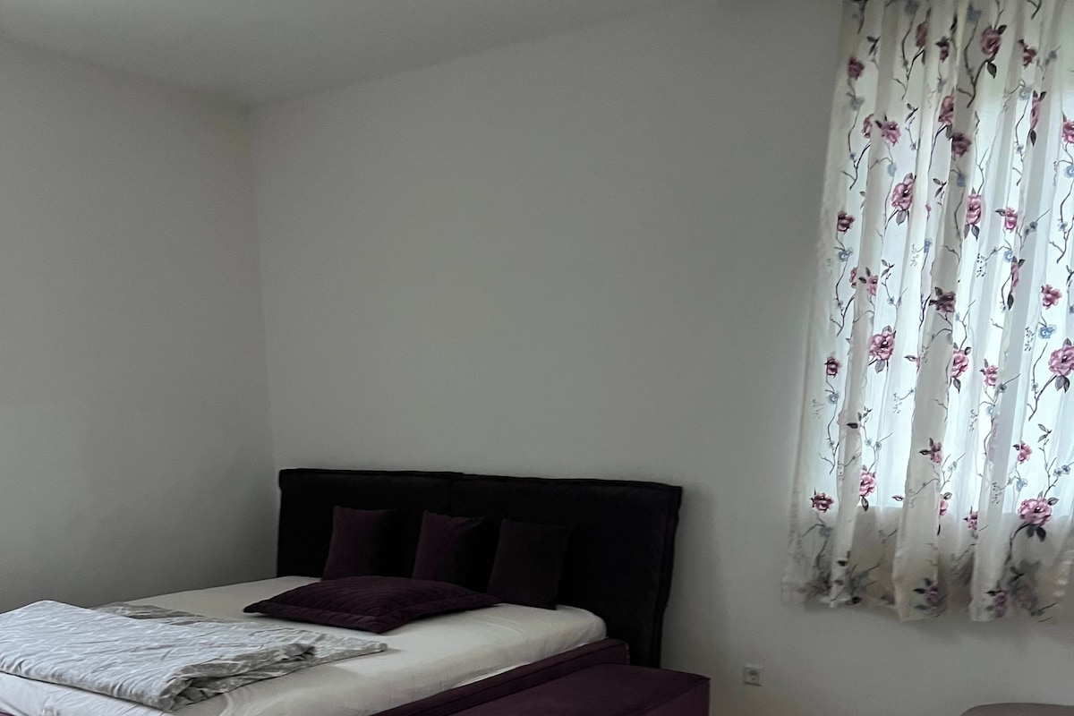 Une chambre à coucher avec un lit, un tapis et une fenêtre avec des rideaux.