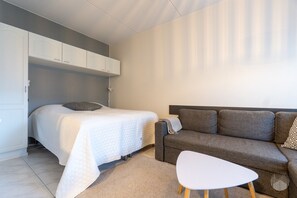 A bedroom with a bed, a sofa, and a small table. - Cozy and peaceful apartment in Äkäslompolo (Äkäslompolo)