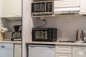 A kitchen with a microwave, coffee maker, and dishwasher. - Cozy and peaceful apartment in Äkäslompolo (Äkäslompolo)