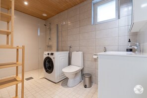 A modern bathroom with a washing machine, toilet, and sink. - Marinan Portin Kapteeni A34 by Holiday in Kalajoki (Kalajoki)