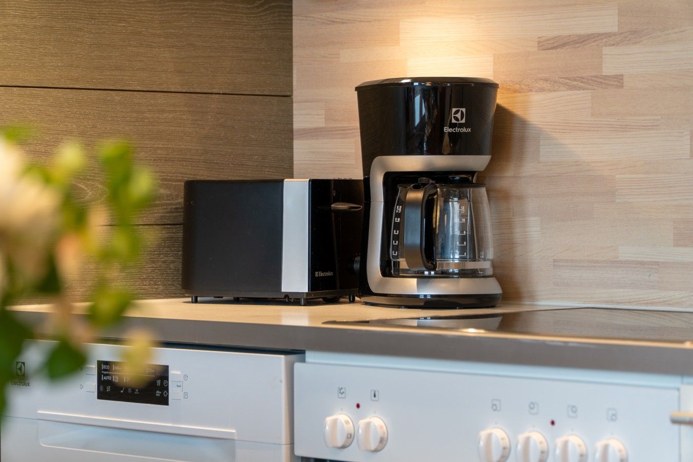 Une cuisine moderne équipée d’une machine à café, d’un four à micro-ondes et d’un lave-vaisselle.