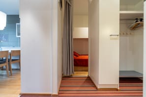 A hotel room with a bed, a wardrobe, and a bathroom visible through an open door.
