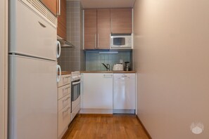 A compact kitchen with a microwave, oven, and dishwasher. - Ylläs Chalet 3208 by Holiday in Lapland (Ylläs)