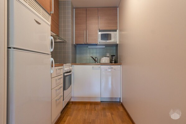 A compact kitchen with a microwave, oven, and dishwasher.