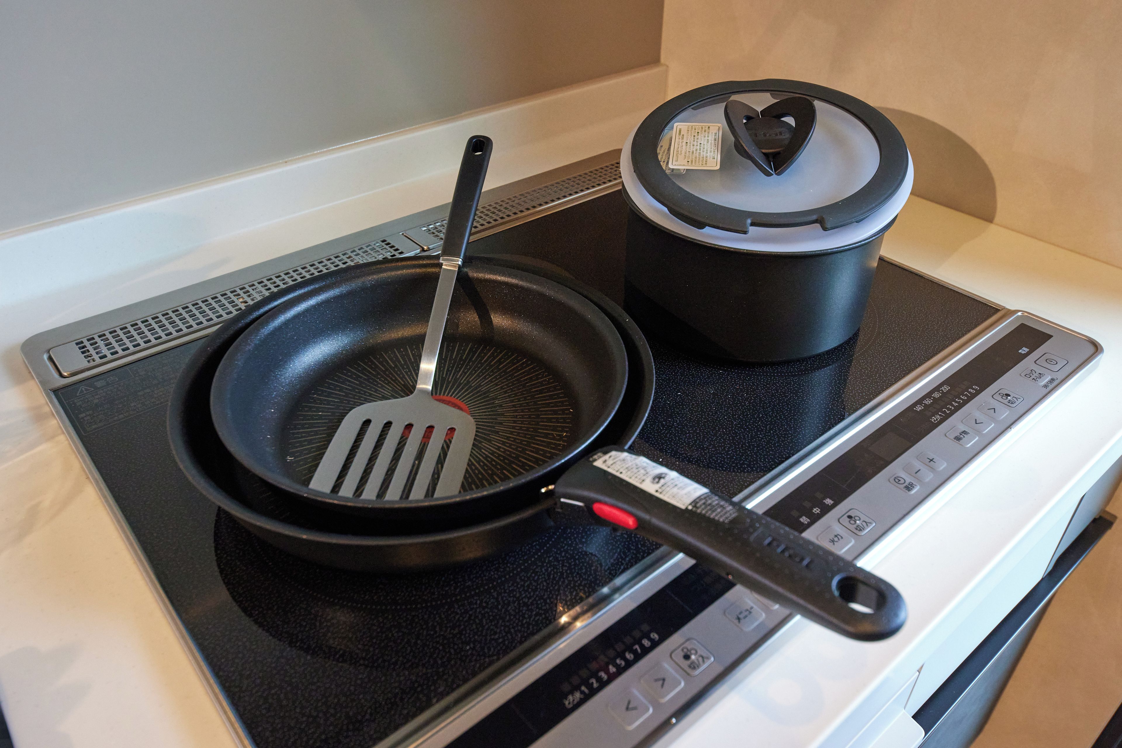 A kitchen with a stove, a frying pan, and a pot.