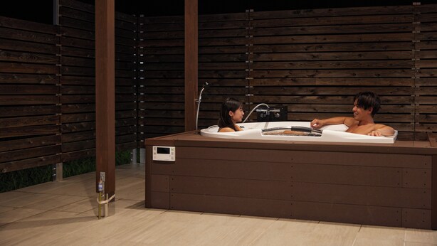 An outdoor hot tub with two people.