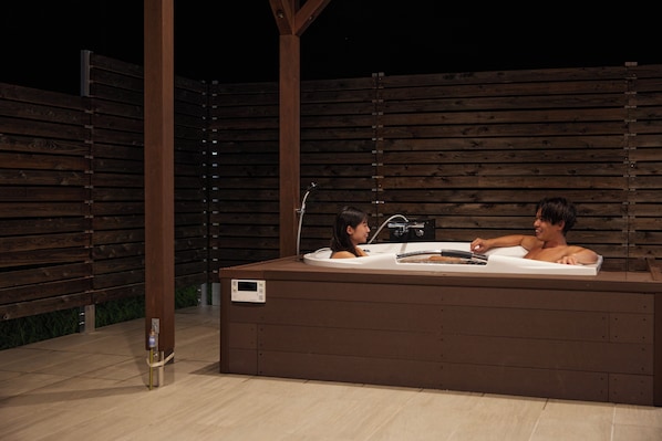 An outdoor hot tub with two people.
