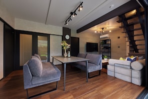 Una sala moderna con un sofá, una mesa y una escalera.