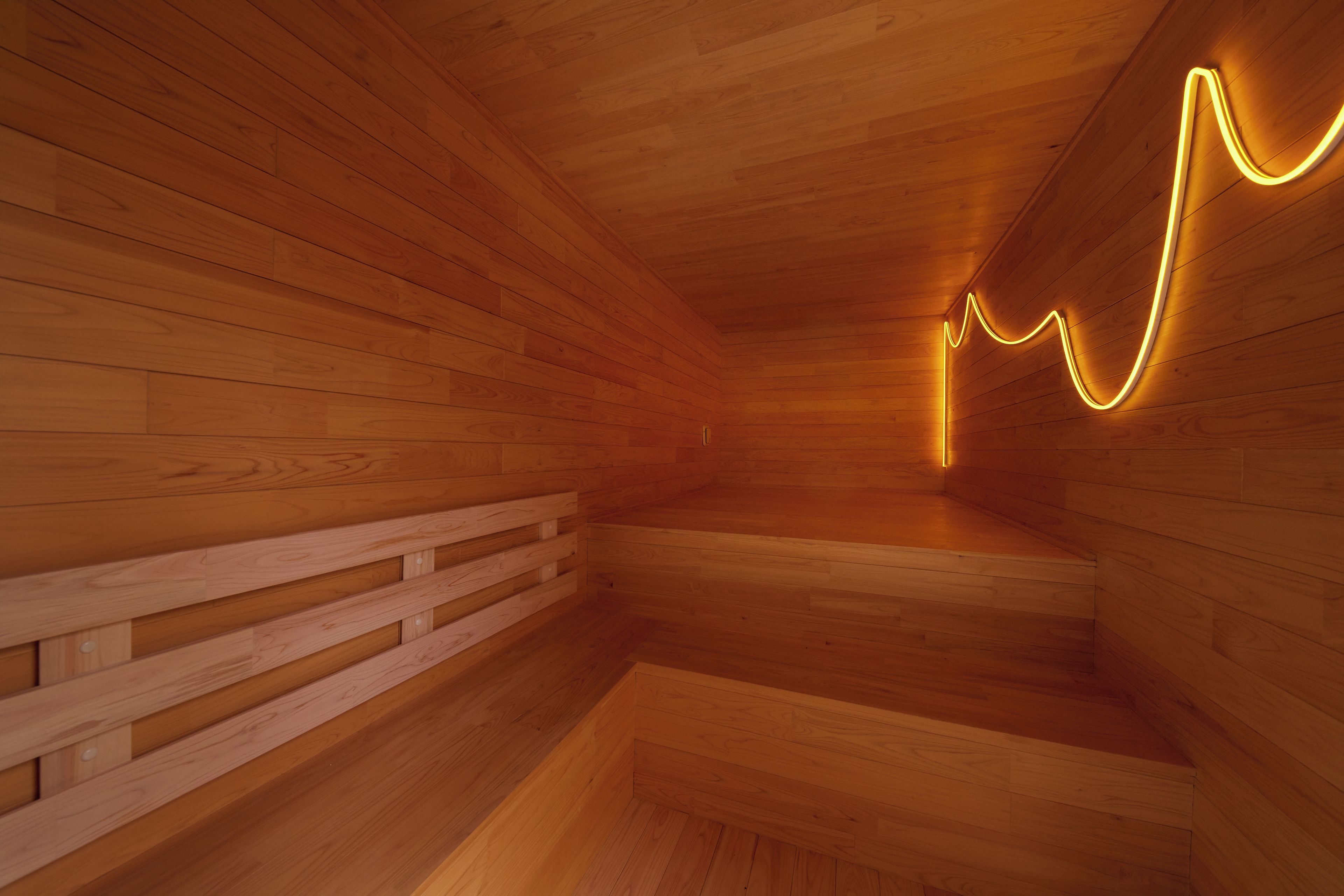 A wooden interior with a curved neon light design on the wall.