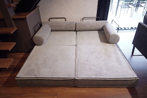 Una habitación moderna con un sofá cama grande y plegable y una escalera.