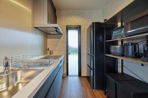 A modern kitchen with stainless steel appliances, a built-in oven, and a large window.