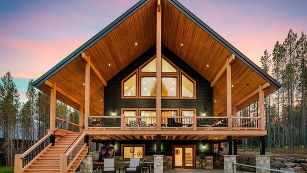 A large, two-story lodge with a prominent wooden exterior, a balcony, and a tennis court in front. - Emerald Pines Lodge+HotTub+Cent AC+20mYellowstone (Island Park)