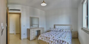 A bedroom with a bed, a dresser, a mirror, and a window. - Family apartment in Shkoder: balcony, work corner, free parking (Shkodër)