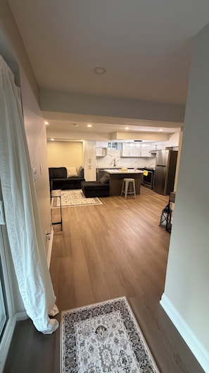 A modern kitchen with white cabinets, a central island, and stainless steel appliances. - Clean comfortable charming Beamsville stay (Lincoln)