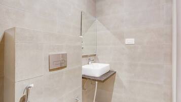 A modern bathroom with a shower, a sink, and a mirror.