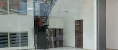 A modern interior with a glass door leading to a staircase.