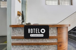 A reception desk with a sign that reads 'HOTELO' and 'Company-Served.'