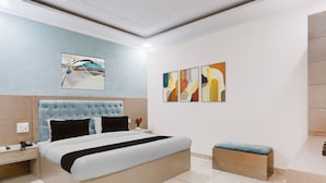 Un dormitorio moderno con una cama grande, una mesita de noche y un pequeño banco.