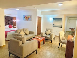 Una sala moderna con un conjunto de sofás, una mesa de centro y un comedor con una mesa y sillas.